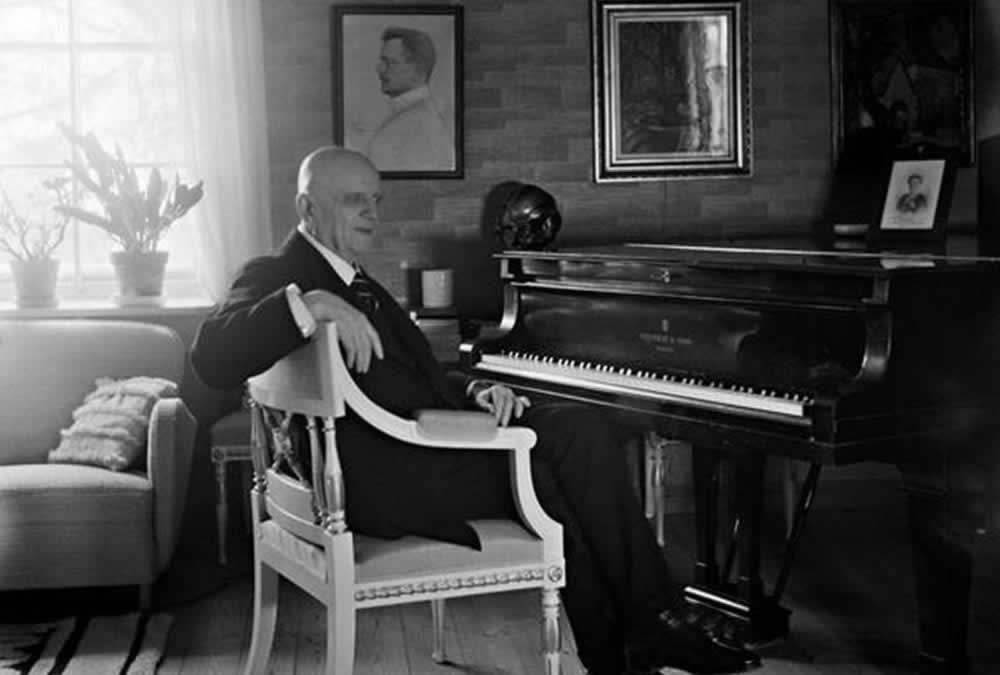Jean Sibelius istumassa pianonsa ääressä Ainolassa